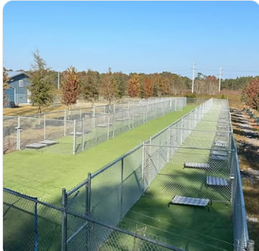 Galvanized chain link enclosure running the length of a synthetic turf athletic field